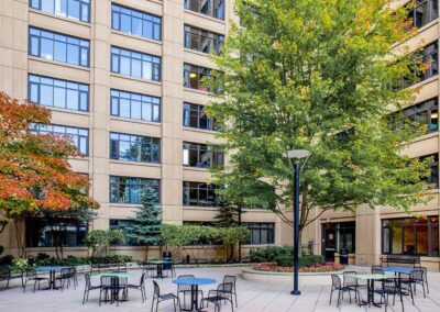 View of outdoor terrace on 3rd floor of UC with open tables with chairs and vibrant greenery.